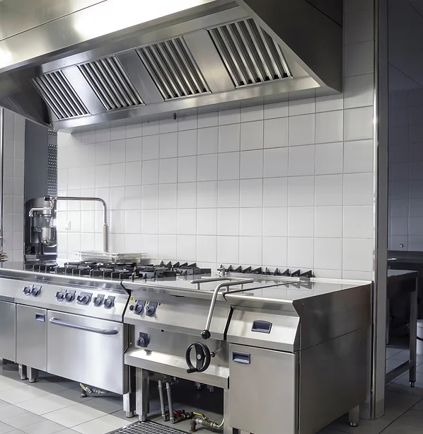 a commercial kitchen area with ventilation hoods and several cooking stations